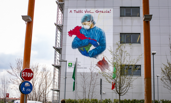 De Italiaanse ziekenhuizen kunnen het aantal coronaviruspatiënten niet aan... maar ze hebben de volledige steun van de bevolking, zoals dit gigantische fresco in Bergamo laat zien. (Foto Belga, Sergio Agazzi)