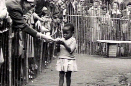 Het Congolese paviljoen tijdens de Expo van '58. Zwarte mensen worden tentoongesteld als dieren in een dierentuin.